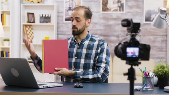 Famous Young Vlogger Recording a Review of a Book