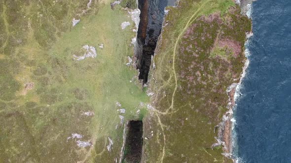 Topdown overview drone shot of ocean cliffs. Aerial video shot in Scotland, highland landscape.