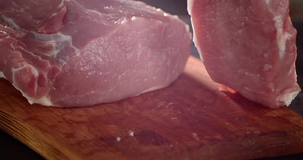 The Men's Hand Puts a Piece of Raw Pork on a Cutting Board. 