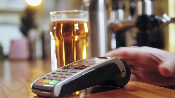 Buying Beer and Paying By Smartwatch Via Terminal Closeup