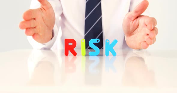 Businessman showing the word risk with alphabet