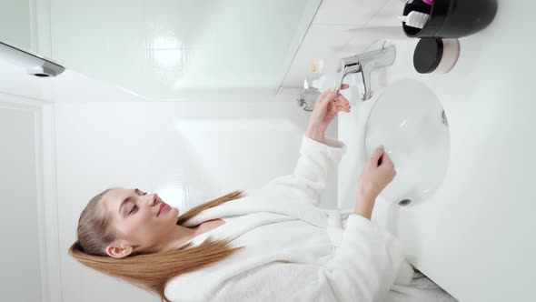 Brunette Woman in White Terry Robe Washing Hands