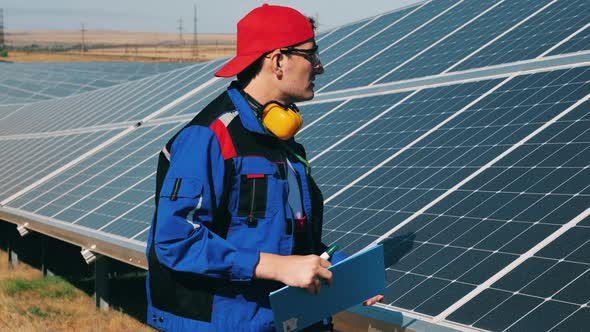 Solar Energy Engineer Checking Solar Panels at a Solar Power Facility