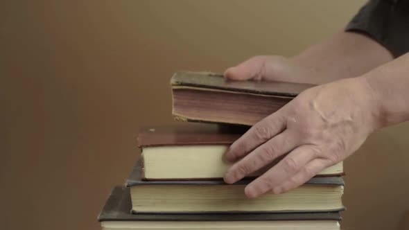 Stacking a collection of old books into a pile