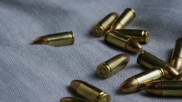 Cinematic rotating shot of bullets on a fabric surface 