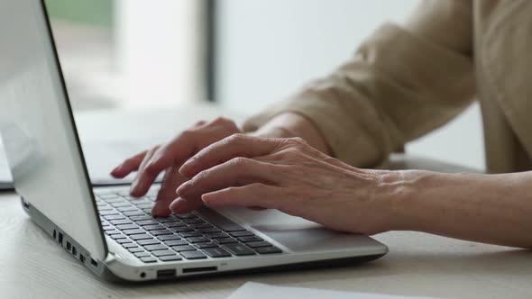 The Hands of an Elderly Woman on the Keyboard a Grandmother at a Laptop at Home