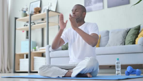 Young African Man Meditating on Yoga Mat at Home