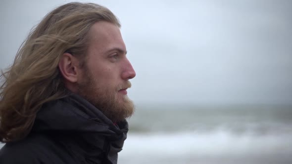 Portrait in Profile of Manly Male Explorer with Long Brown Hair Taking Pleasure in Force of Nature