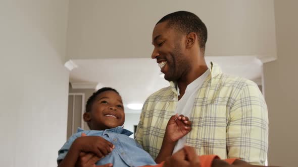 Father playing with his son in living room 4k