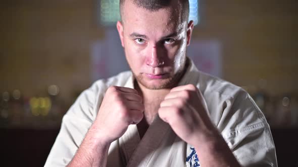 Fighter stands in a fighting stance, then looks up and looks at the camera