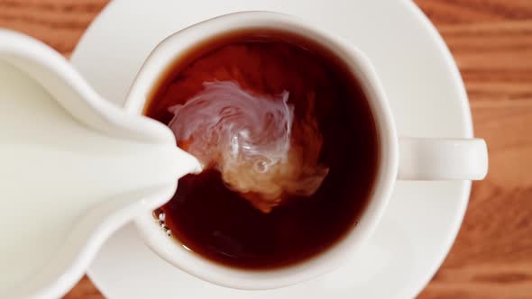 Pouring Milk Into Black Tea Top View