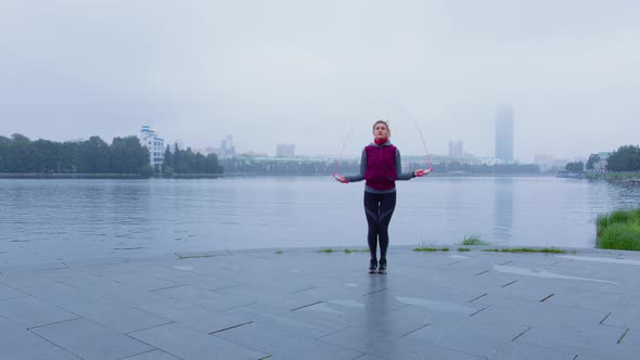 Slender Girl in Warm Sportswear is Jumping Rope