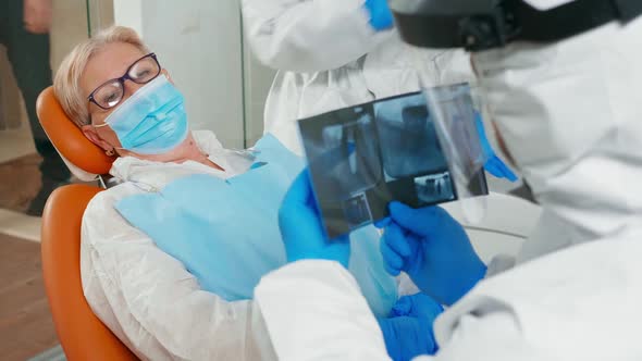 Doctor with Face Shield Reviewing Panoramic Dental Xray Image