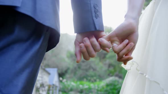 Groom holds little finger of bride 4K 4k