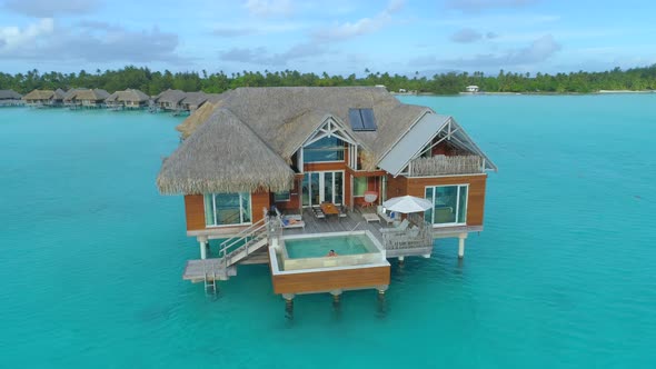 Aerial drone view of a luxury resort and overwater bungalows in Bora Bora tropical island.