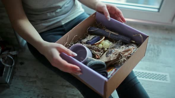 The Girl is Holding a Christmas Present in a Box