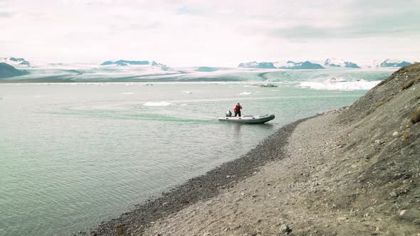 Man Disembarks From A Boat In Jökulsárlón Lagoon - wide shot