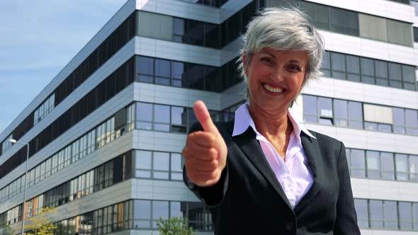 Business Middle Age Woman Smiles and Shows Thumb Up To the Camera - Company Building