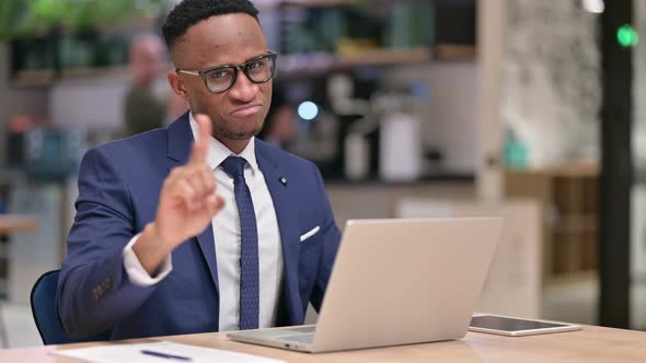 African Businessman with Laptop Showing No Sign in Office 