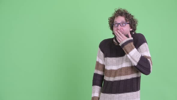 Happy Young Bearded Man Touching Something and Looking Surprised