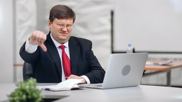 Portrait of Disappointed Male Boss with Unhappy Expression Showing Thumb Down