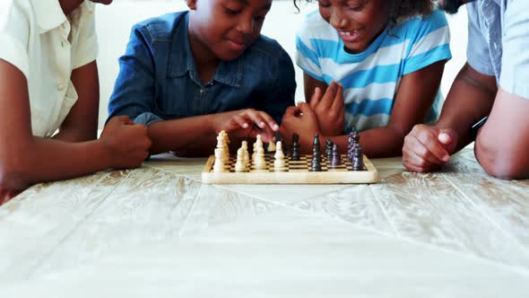 Family playing chess together at home in the living room