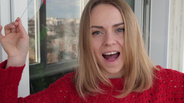 Young Blonde Girl in Red Sweater Holding Red Hearts Showing Emotions