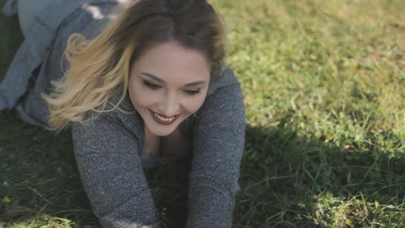 Blond Woman Lay on Green Grass Closeup