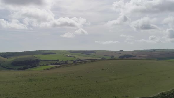 Aerial tracking back from the edge of the northern rampart of Maiden castle to reveal the size and g