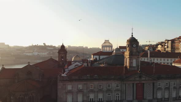 Reveal of Douro River embankment from Palácio da Bolsa in Porto, Portugal - Aerial slow pan shot