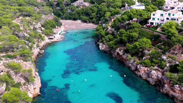 Cala Pi Beach in Mallorca Spain with turquoise waters and buoys, Aerial dolly out reveal shot