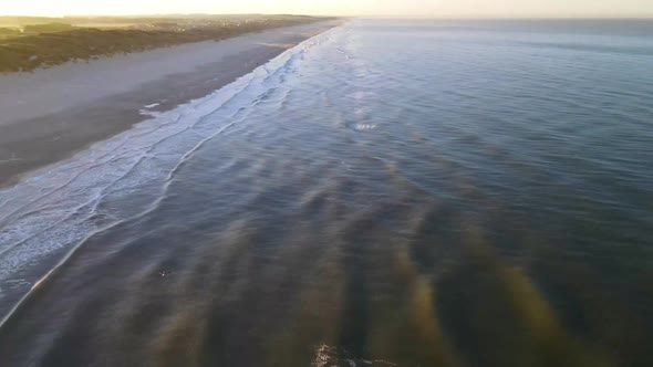 Aerial view of rolling waves and sunrise at the ocean close to Løkken by the North Sea, Denmark