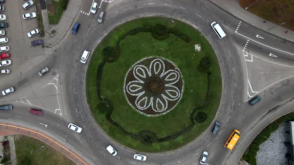 4k aerial view of roundabout road with circular cars in small european city at cloudy autumn day