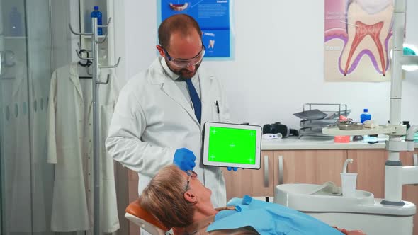 Stomatologist Looking at Green Screen Tablet