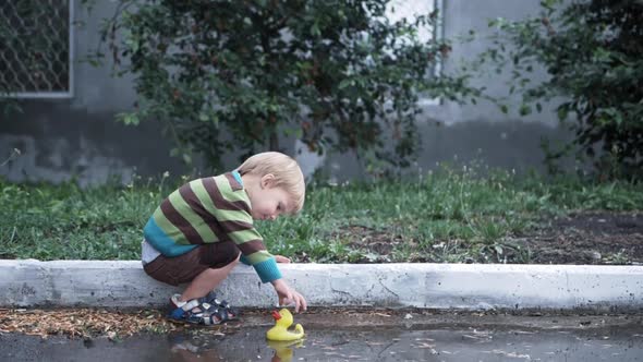 Vacation Kids, Little Boy Have Fun Playing Rubber Duck for Swimming in Puddle