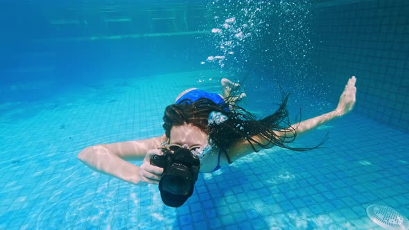 Travelling Girl in Asia. Happy Young Woman with Beautiful Long Hair Swim Under Water with Camera in