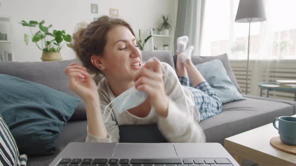 Joyous Woman Taking Medical Face Mask off Chatting on Video Call from Home