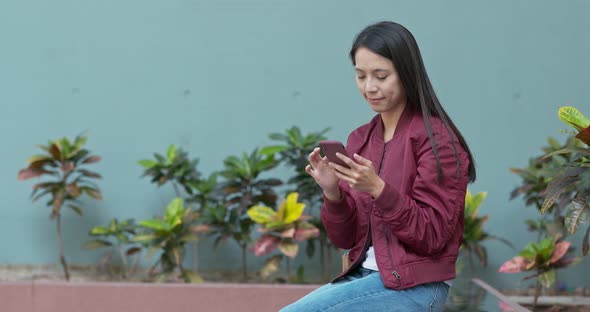 Woman use of mobile phone in city park