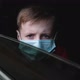 Young Boy in a Medical Mask Looks Through the Car Window and Lifts the Glass. - VideoHive Item for Sale
