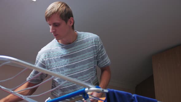 A Man Hangs Clothes To Dry