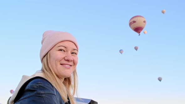 Pretty Happy Smiling Woman in Pink Hat and Black Leather Jacket Looks Into Frame Then Turns Away and