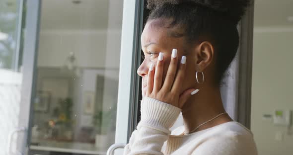 Video of crying african american woman looking outside window