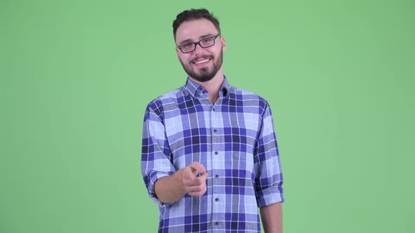 Happy Young Bearded Hipster Man Pointing at Camera