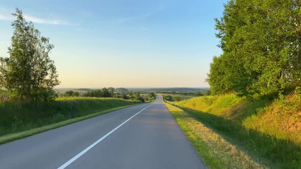 Driving on a rural road on the car at sunset