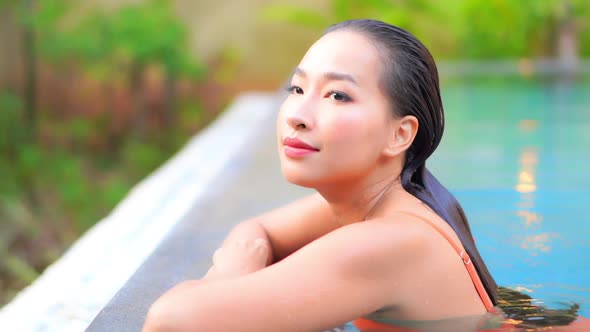 Young asian woman enjoy around outdoor swimming pool for leisure