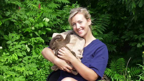 vet cares for baby sloth in jungle and smiles at camera 4k