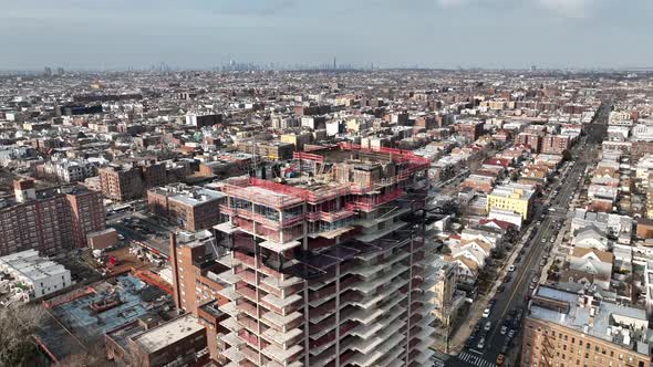 A high angle view above a new building construction in Brooklyn, NY with NYC in the background. The