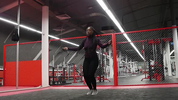 Sports in the Gym  Africanamerican Woman Jumping Over the Rope  Endurance Exercise