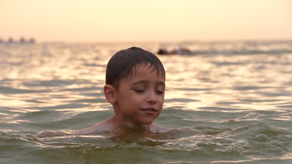 A Happy Active Child is Floating on the Waves