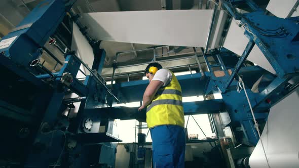 Factory Inspector Is Observing Paper Rolling Through the Equipment